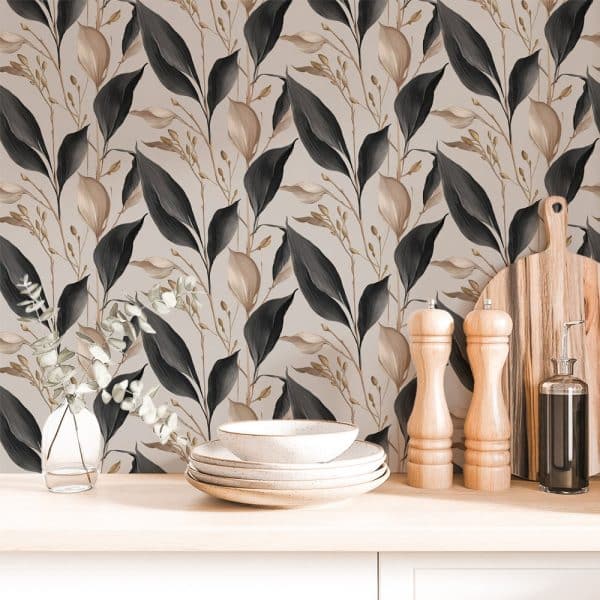 Beige Kitchen Counter With Stacked Dishes, Salt And Pepper Shakers, And A Cutting Board In Front Of A Wall With Dark And Beige Leaf Patterned Wallpaper.