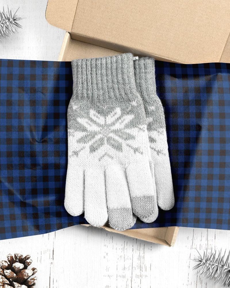 Pair of gray and white knit gloves with snowflake pattern in a gift box.