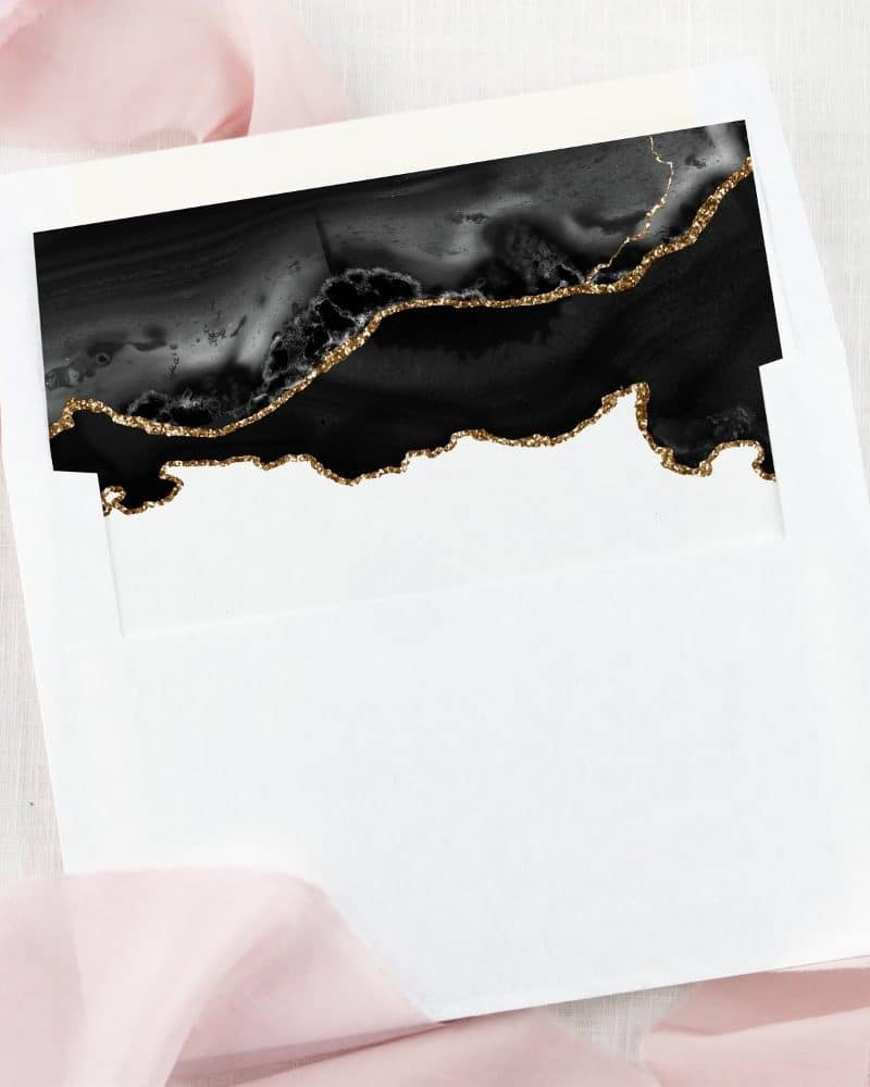 White envelope with a black and gold glitter agate design at the top.