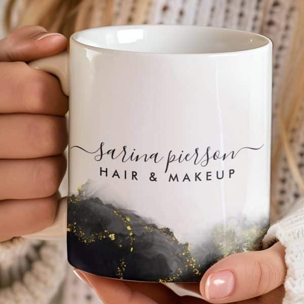 White Coffee Mug With The Name Sarina Pierson Hair &Amp; Makeup And A Gray And Gold Design.