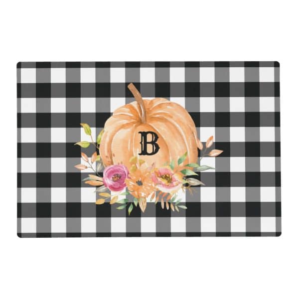 Black And White Checkered Placemat Featuring A Watercolor Pumpkin With The Letter B And Autumnal Flowers.