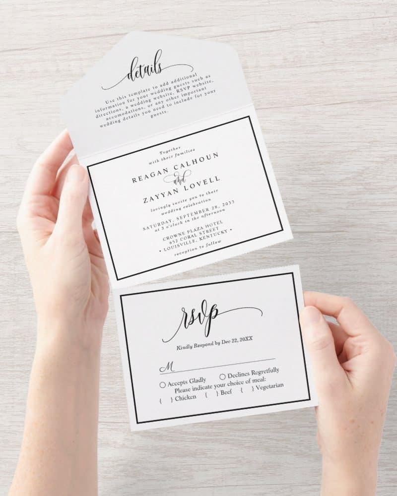 Hands hold a tri-fold wedding invitation with an RSVP card. The invitation features the names Reagan Calhoun and Zayyan Lovell, wedding date, time, and location.