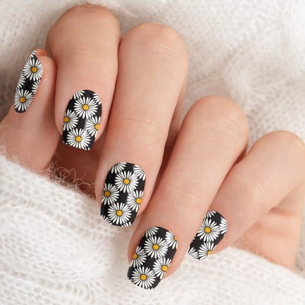 Close-Up Of Fingernails With A Black And White Daisy Pattern.