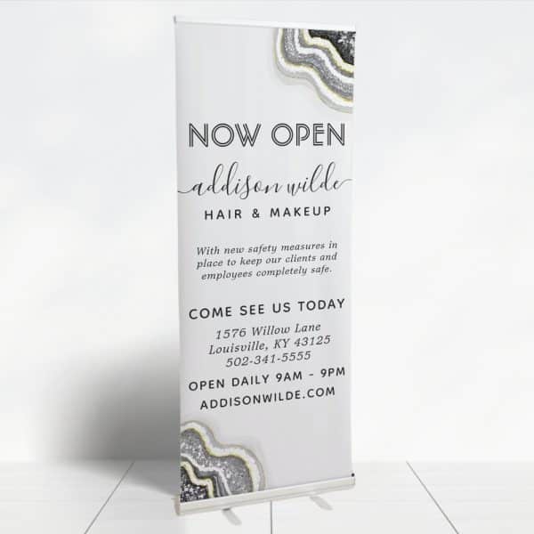 A Retractable Banner Announcing The Grand Opening Of Addison Wilde Hair &Amp; Makeup Salon, Including The Address And Hours.