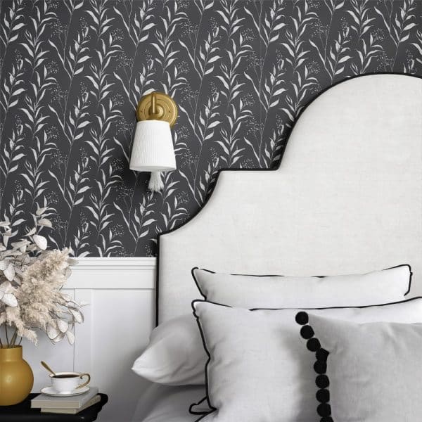Dark Gray Wallpaper With A Repeating Pattern Of White Stylized Leaves And Branches, Partially Visible Behind A White Headboard.