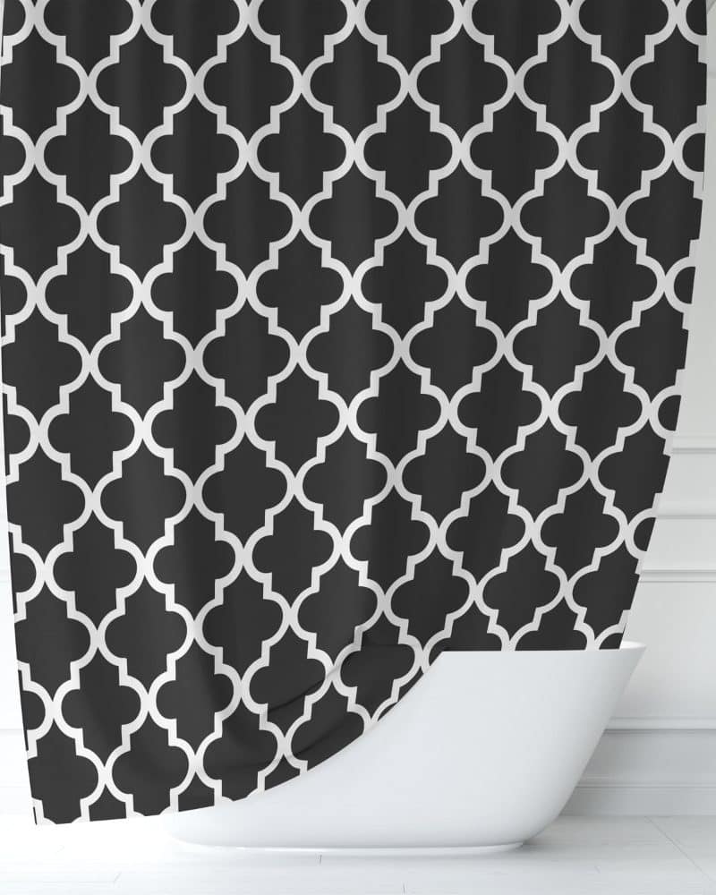 Black shower curtain with a white quatrefoil pattern.