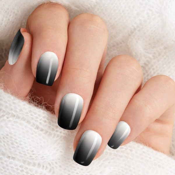 Close-Up Of A Hand With Ombre Nails Transitioning From White To Black.