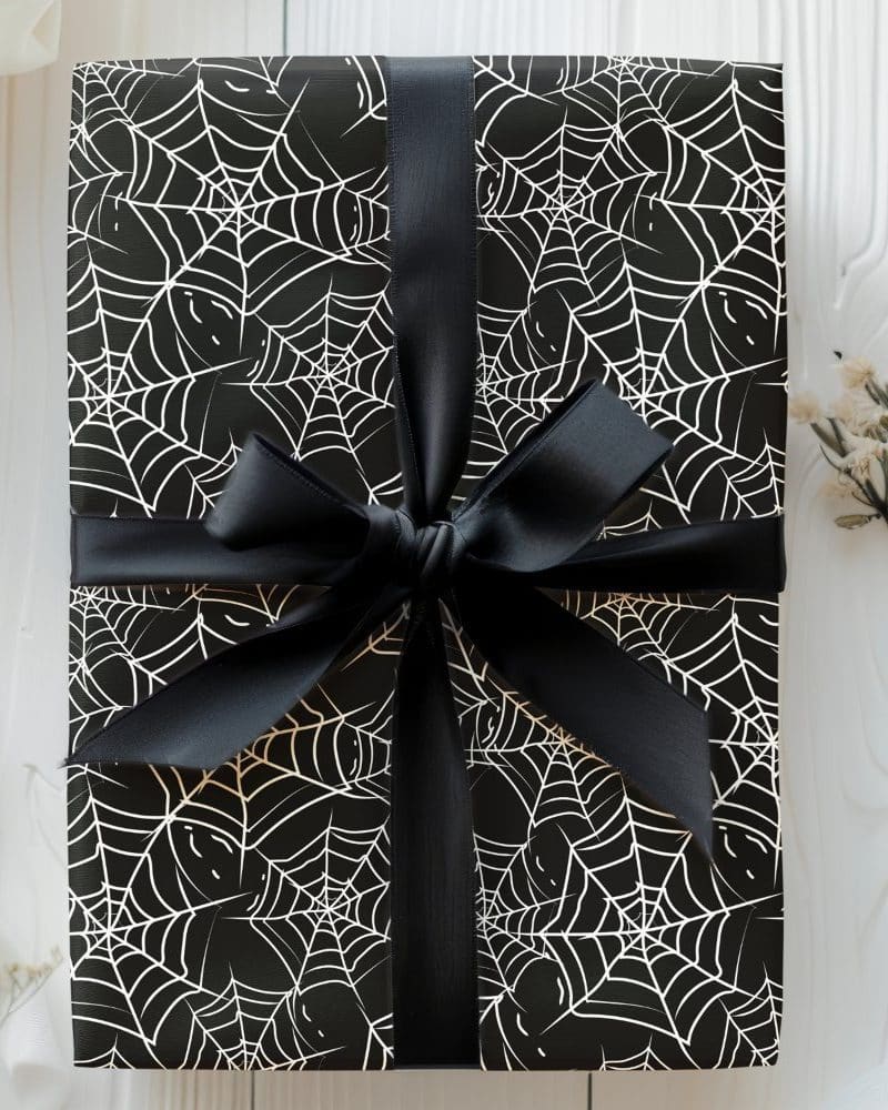 Black gift box with white spiderwebs and a black ribbon.