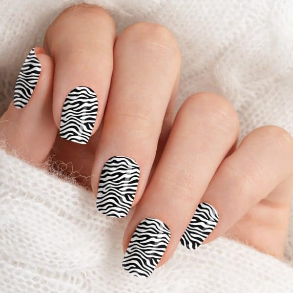 Close-Up Of A Hand With Fingernails Painted In A Black And White Zebra Stripe Design.