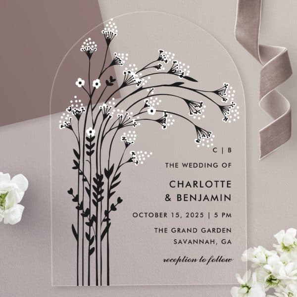 Arch-Shaped Clear Acrylic Wedding Invitation With Black Floral Design And White Details, Featuring The Couple'S Names And Wedding Details.