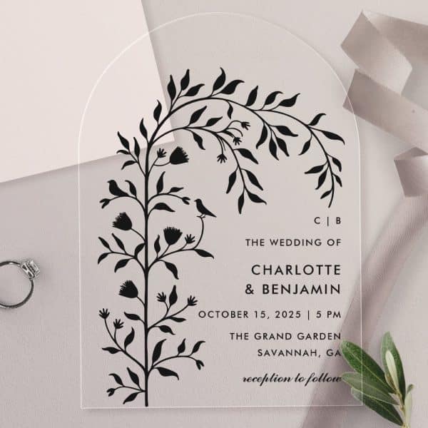 Arch-Shaped Clear Acrylic Wedding Invitation With Black Floral Illustration And Wedding Details.