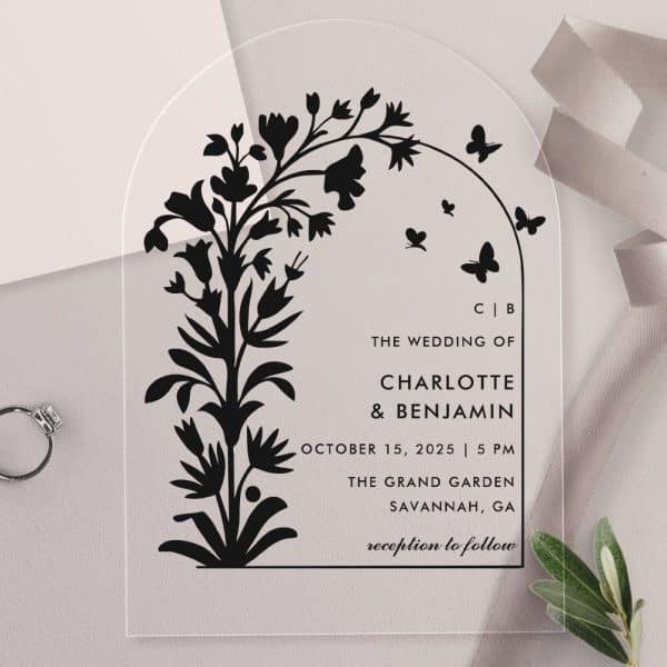 Arch-Shaped Clear Acrylic Wedding Invitation With Black Floral Illustration And Wedding Details.