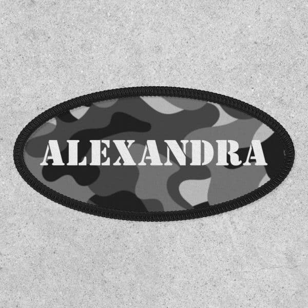 Oval Camouflage Patch With The Name Alexandra In White Lettering.
