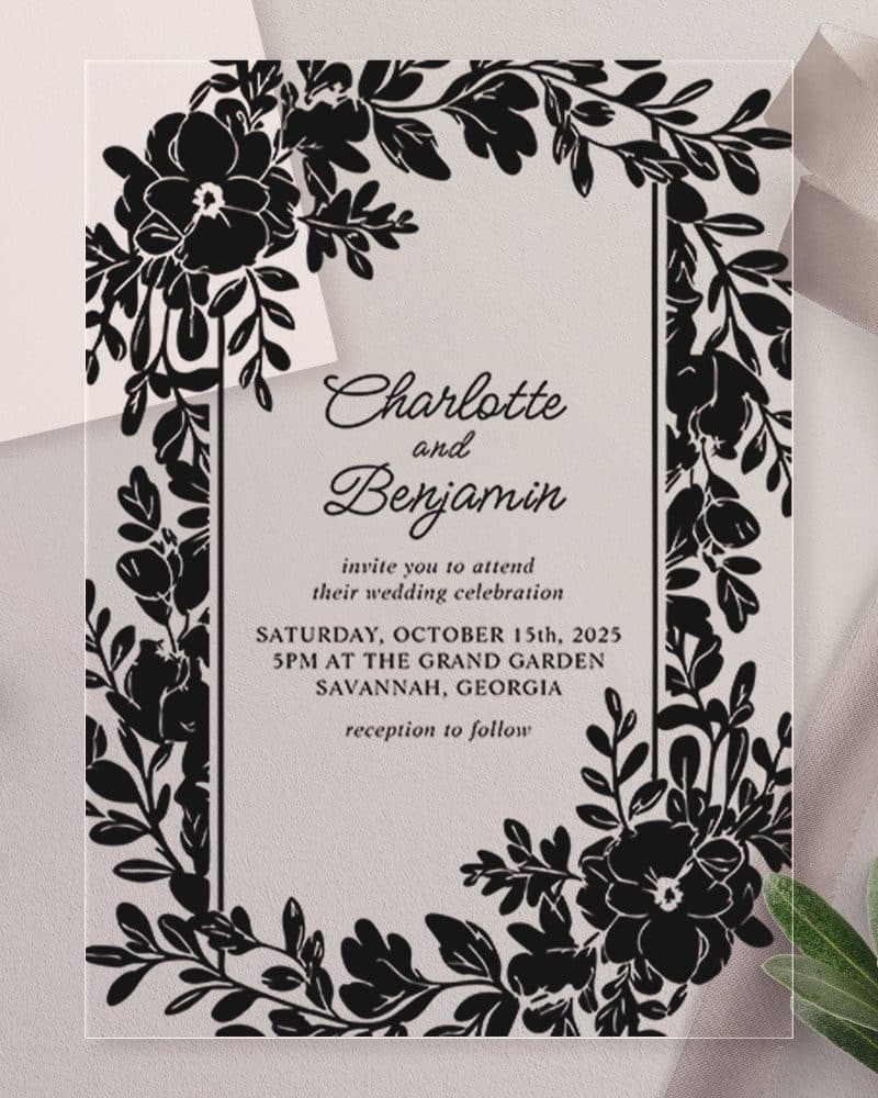 Clear wedding invitation with black floral border, announcing Charlotte and Benjamin's wedding.