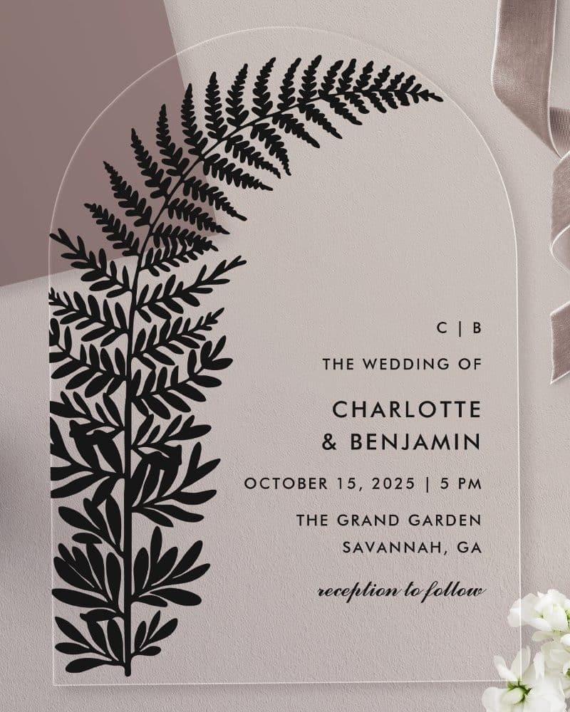 Arch-shaped wedding invitation with a black fern illustration and wedding details.