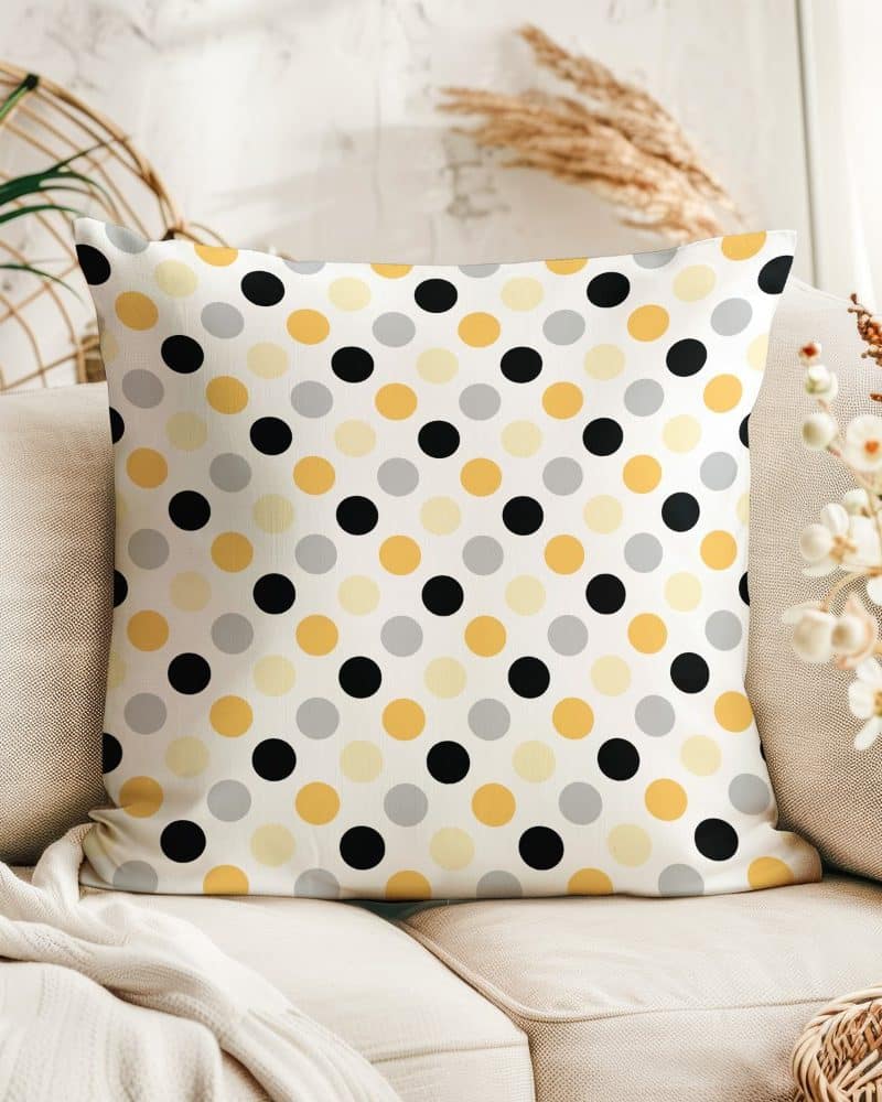 Square throw pillow with black, gold, and gray polka dots on a white background.