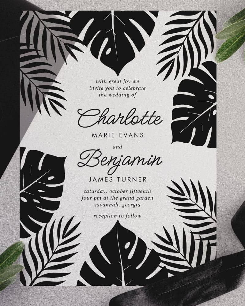 Black and white wedding invitation featuring tropical leaves and announcing the marriage of Charlotte Marie Evans and Benjamin James Turner.