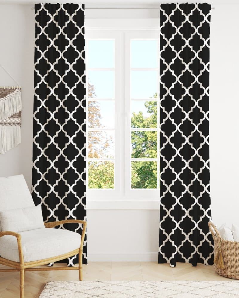 Black and white geometric patterned curtains hanging in front of a window.