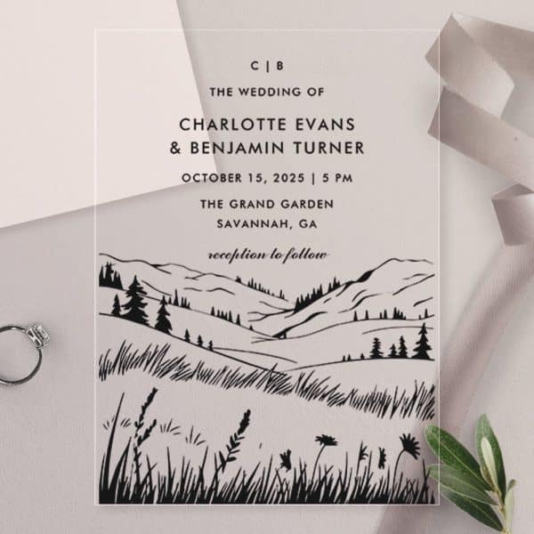Clear Wedding Invitation With Black Ink Illustration Of A Mountainous Landscape And Wedding Details.