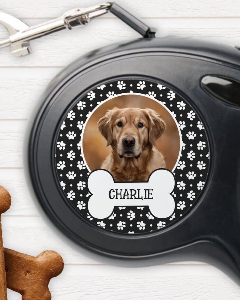 Black retractable dog leash with a custom design featuring a golden retriever's photo, the name Charlie, and paw prints.