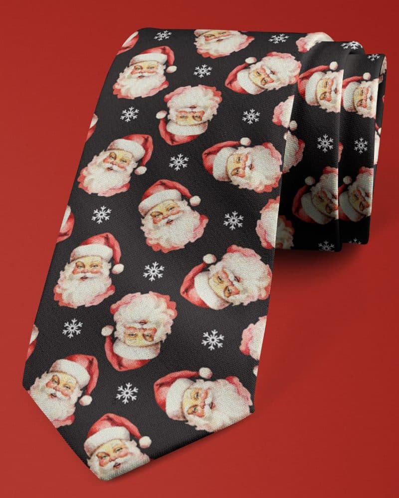 Black necktie with a repeating pattern of Santa Claus faces and snowflakes.