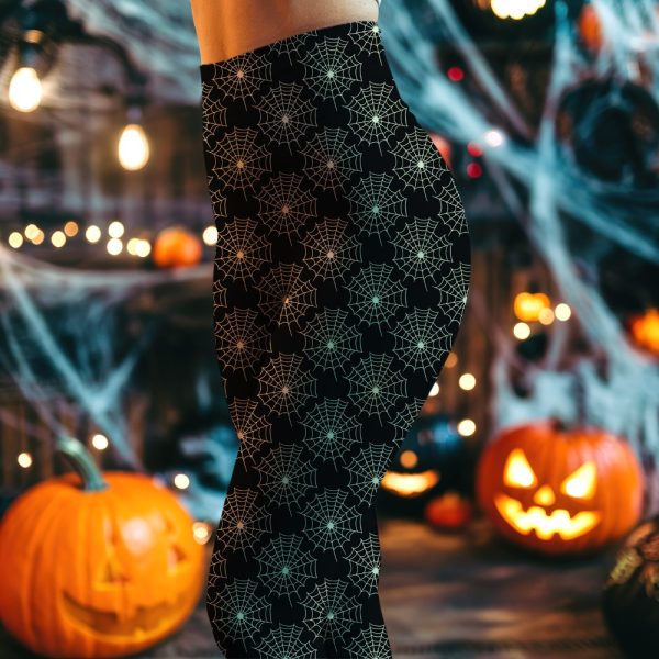 Close-Up Of A Person'S Lower Body Wearing Black Leggings With A Pattern Of Light Green Spiderwebs.