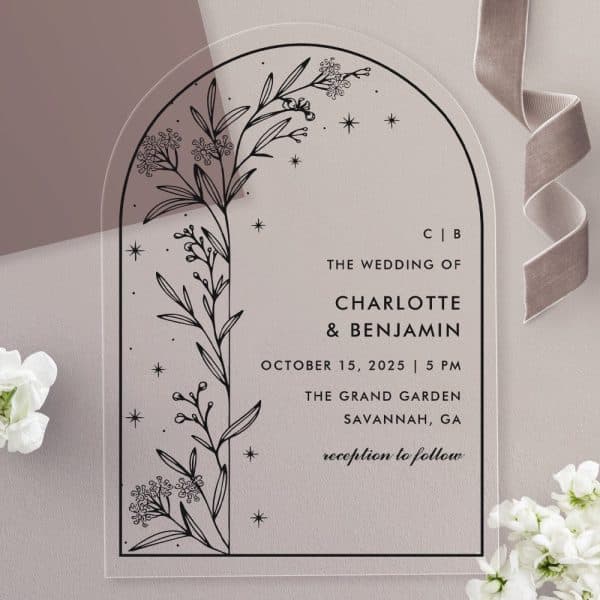 Arch-Shaped Clear Acrylic Wedding Invitation With Black Floral Illustration And Wedding Details.