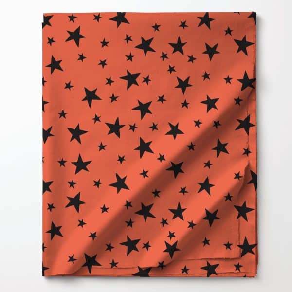 Coral Fabric With A Pattern Of Black Stars.