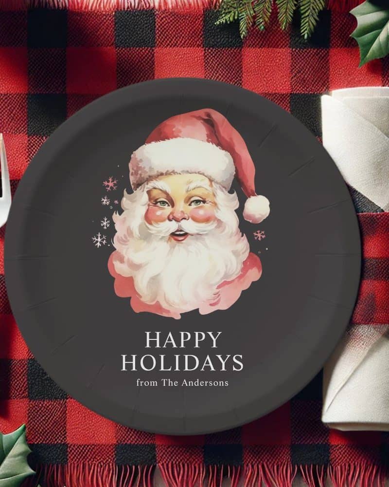 Dark-colored paper plate featuring a vintage illustration of Santa Claus, with the text Happy Holidays from The Andersons.