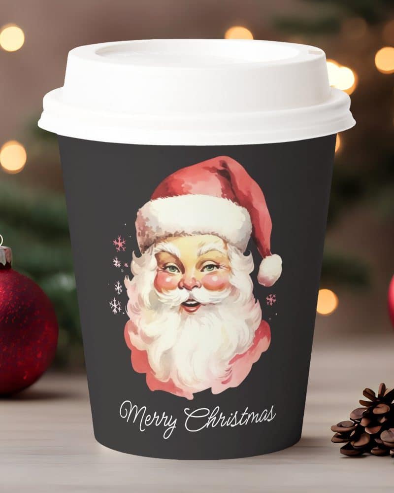 A dark gray Christmas coffee cup features a vintage illustration of Santa Claus. Merry Christmas is written below.