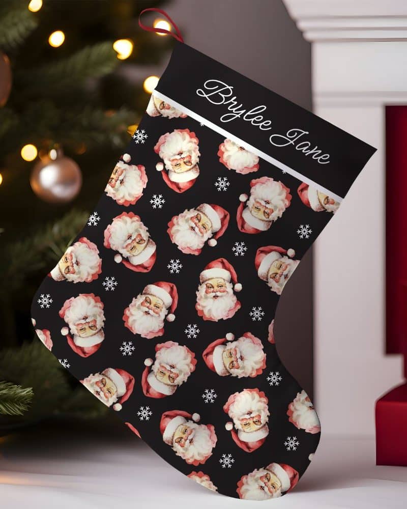 Personalized Christmas stocking with a black background and repeating pattern of Santa Claus faces.