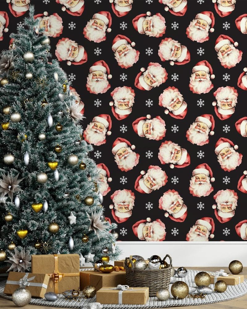 Decorated Christmas tree with presents, in front of a wall featuring a repeating pattern of Santa Claus faces.