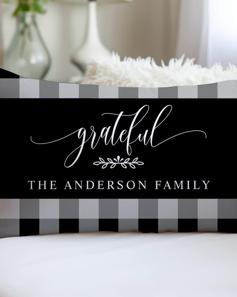 Black and gray buffalo plaid pillow with the word grateful in a script font and the text The Anderson Family.