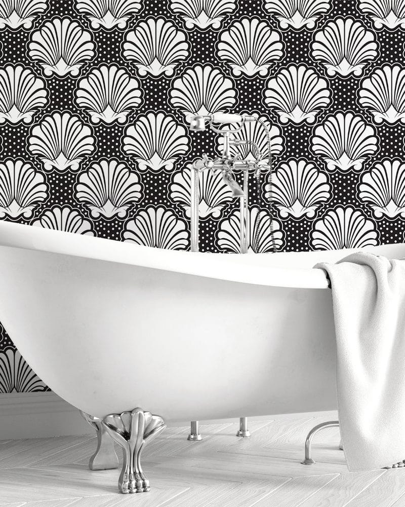 White clawfoot bathtub in front of a black and white shell patterned wall.