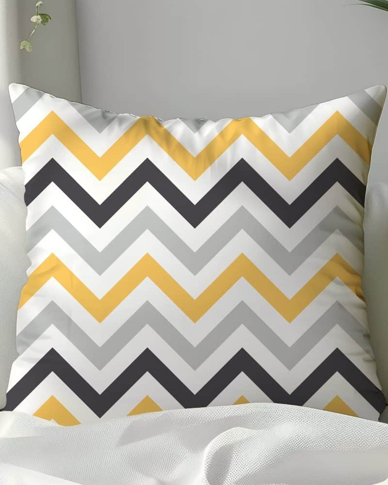 Decorative pillow with yellow, gray, and black chevron pattern.