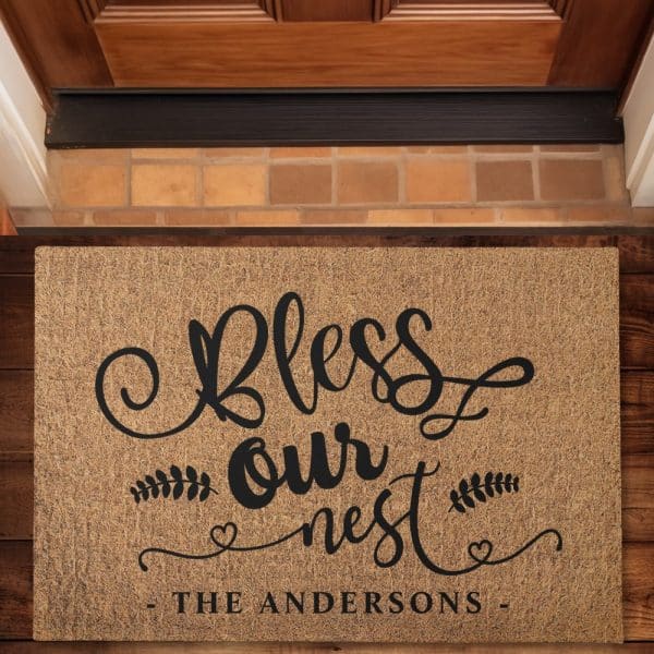 Tan Doormat With Black Lettering That Says Bless Our Nest And The Andersons Family Name.