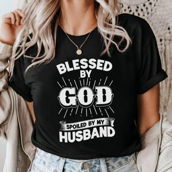 Woman Wearing A Black T-Shirt That Says Blessed By God, Spoiled By My Husband.