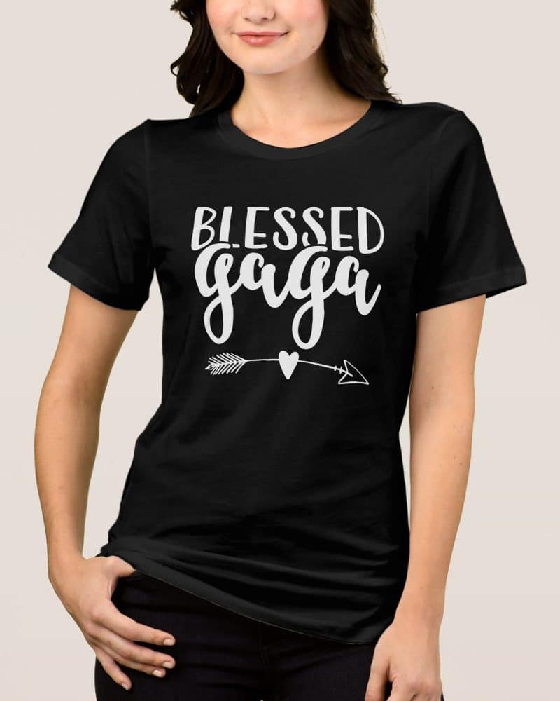 Woman wearing a black t-shirt with the words Blessed Gaga in white lettering and a small arrow and heart graphic.