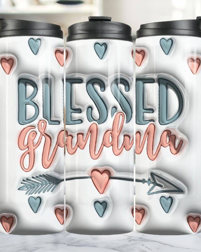 Three travel mugs with a white background featuring the words Blessed Grandma in peach and teal lettering, an arrow, and small hearts.