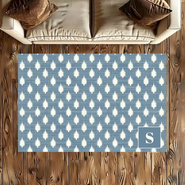 Blue Area Rug With A White Starburst Pattern And A White Letter S In The Corner.