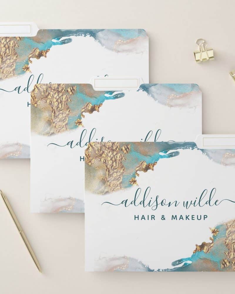Three file folders with an abstract teal and gold design and the name Addison Wilde Hair & Makeup.
