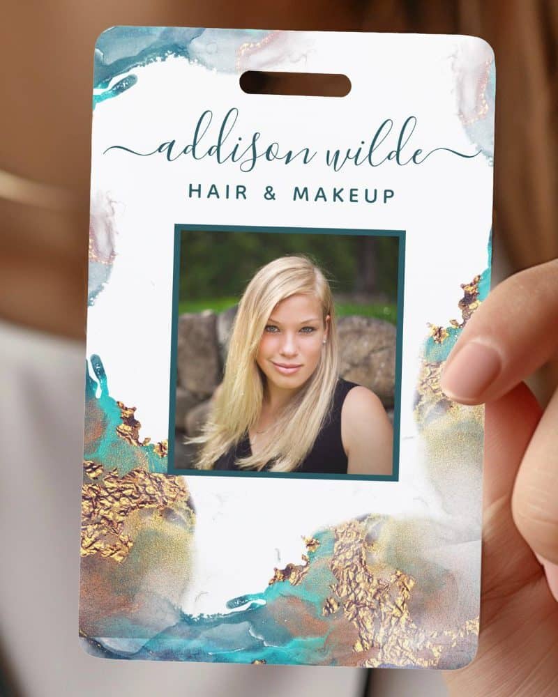 A teal and gold name tag with a woman's photo, reading Addison Wilde, Hair & Makeup.