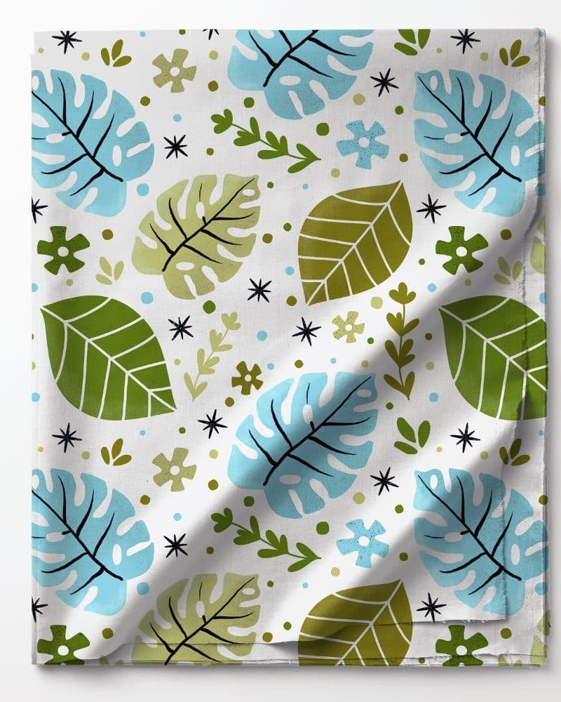 Fabric with a pattern of light blue and green leaves and small flowers.