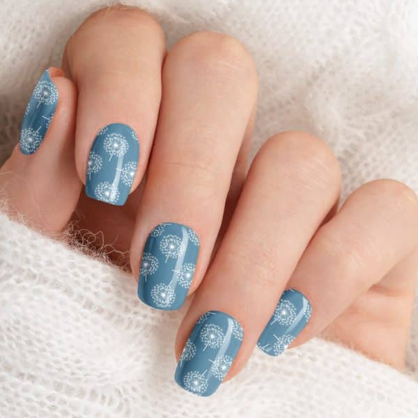 Woman'S Hand With Blue Nails Decorated With A White Dandelion Pattern.