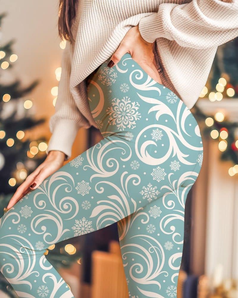 Teal leggings with a cream-colored snowflake and scroll pattern.