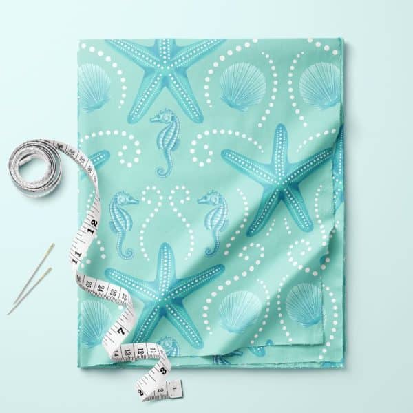 Light Teal Fabric With A Pattern Of Starfish, Seahorses, And Seashells.