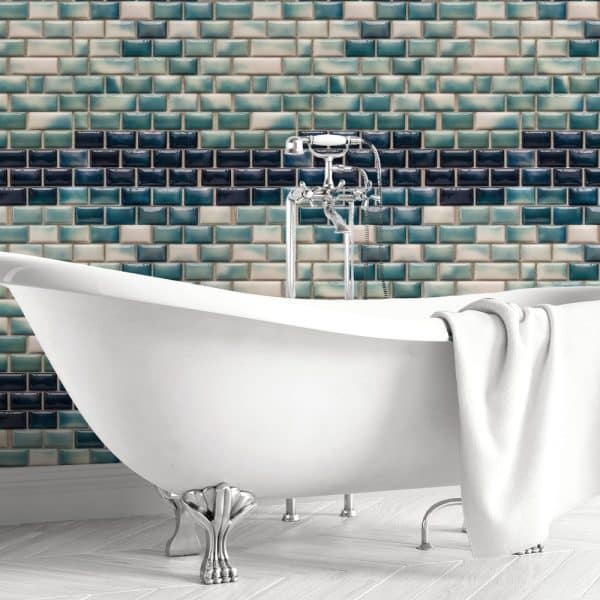White Clawfoot Bathtub In Front Of A Teal And Blue Tile Wall.