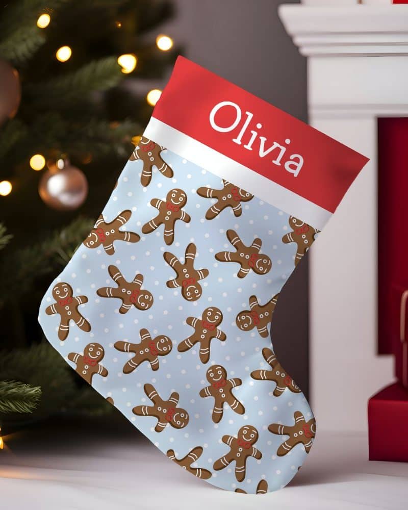 Personalized Christmas stocking with a light blue gingerbread man pattern and the name Olivia.
