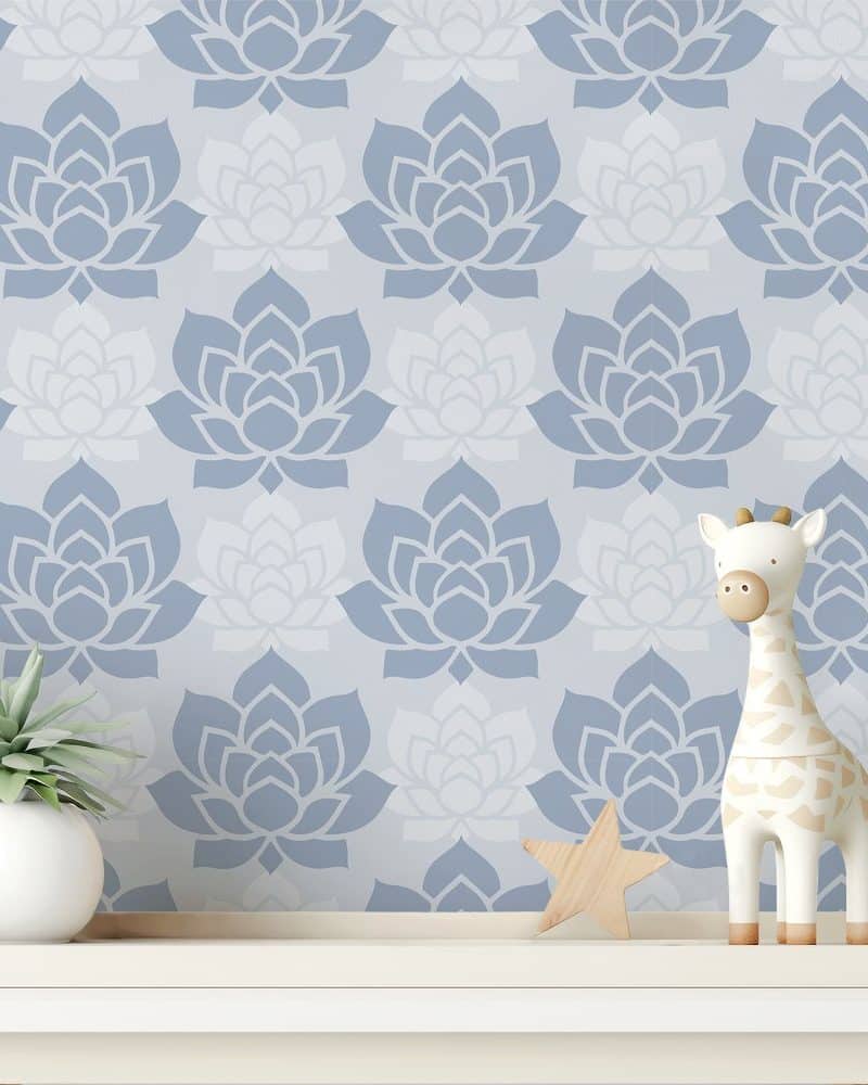 A shelf with a small potted plant, wooden star, and a giraffe toy in front of a wall covered in a blue and white floral pattern.