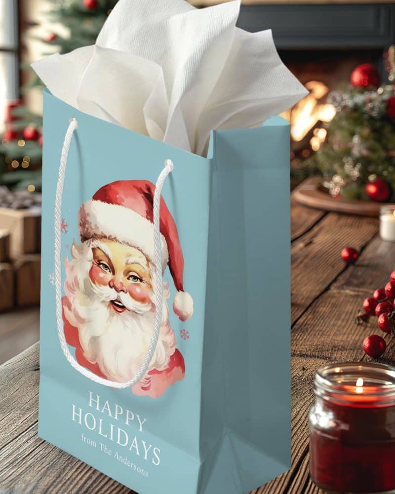 Light blue gift bag with a vintage Santa Claus illustration and the words Happy Holidays from The Andersons.